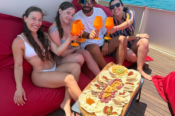 Sunset with dolphins on a vintage tugboat in Golfo Aranci - The aperitif on board: wine, bubbles, and local bites
